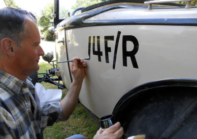 Stéphane Jouny réalisant une peinture en lettres artisanale